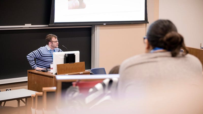 David Cutler teaching from the front of a student newsroom.