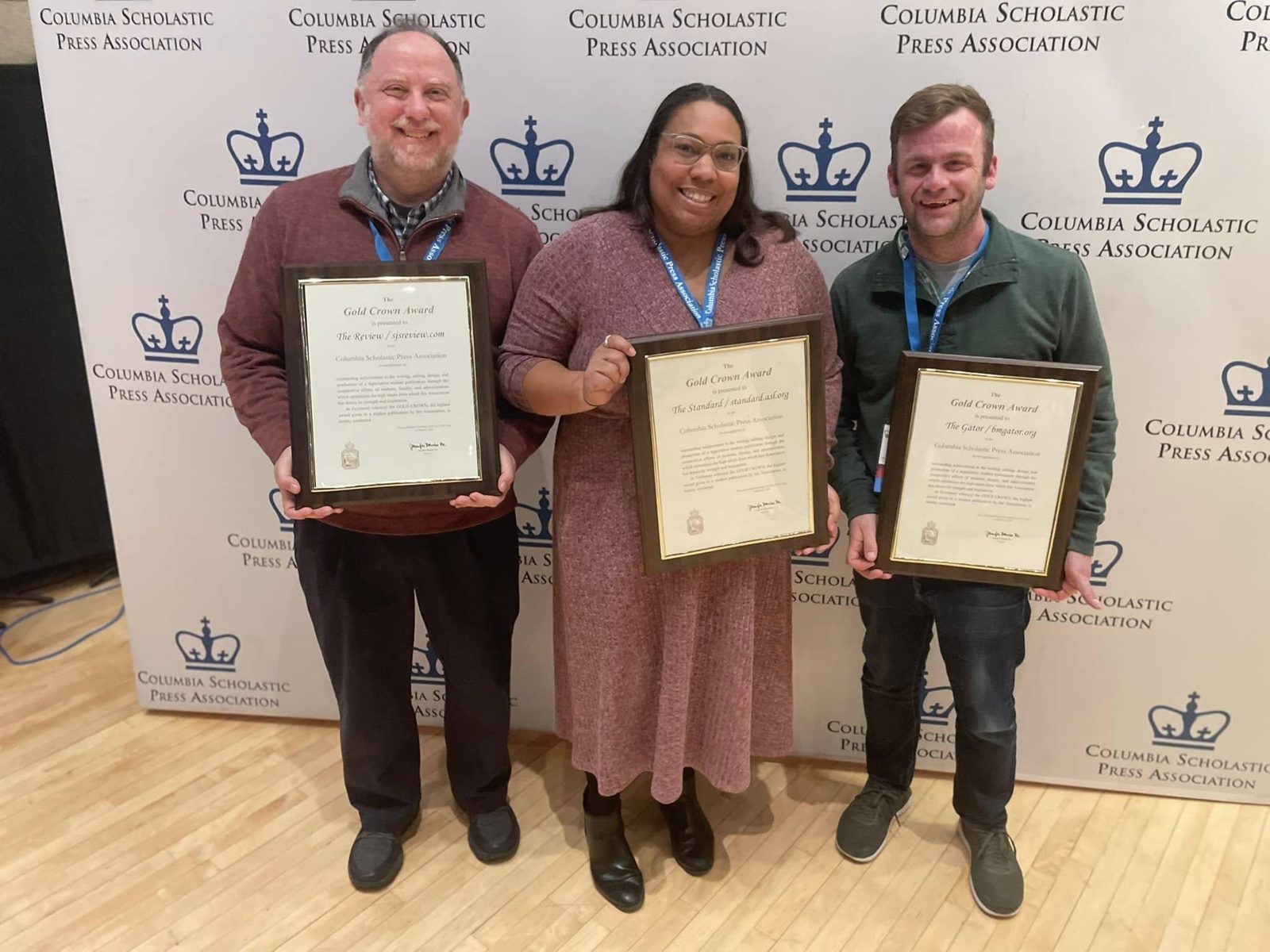 David Nathan, Louisa Avery, and David Cutler display Gold Crown awards for their student publications.