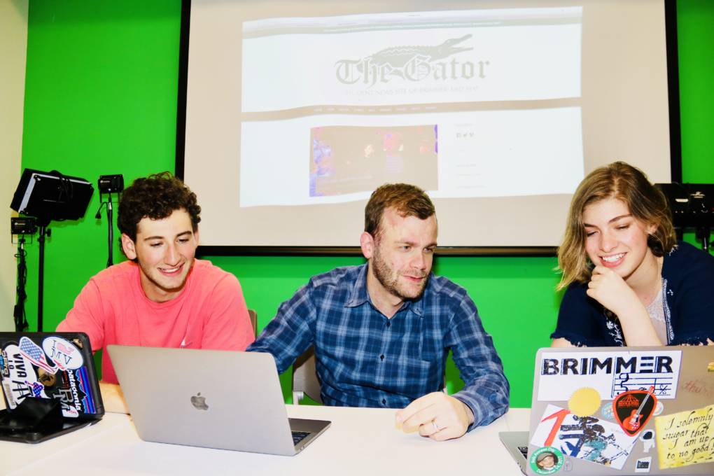 David Cutler seated between student editors Jared Heller and Michelle Levinger, working at laptops in the newsroom.