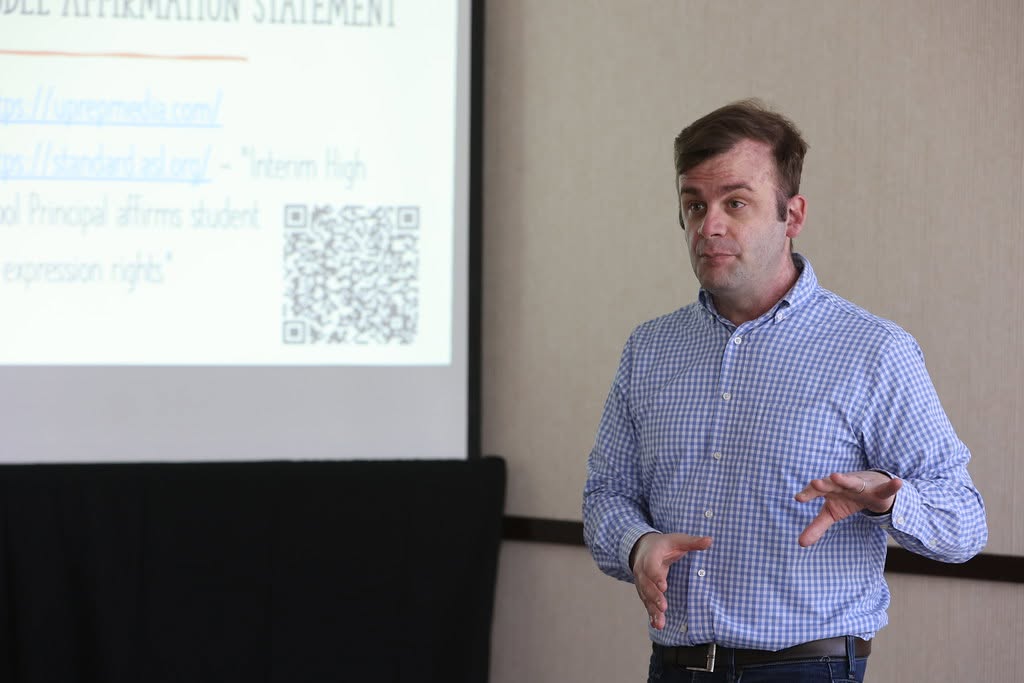 David Cutler presenting beside a projected slide at the JEA/NSPA convention in Nashville.