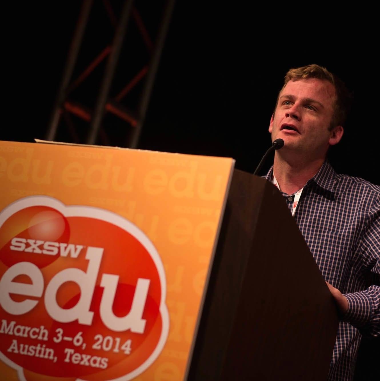 David Cutler speaking into a microphone at the SXSWedu podium.
